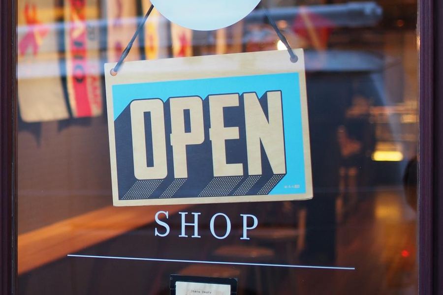 An open sign hanging on a shop door